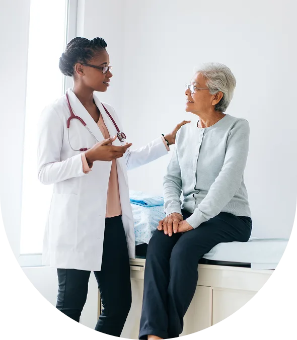 Doctor consulting with an elderly female patient in a clinic.