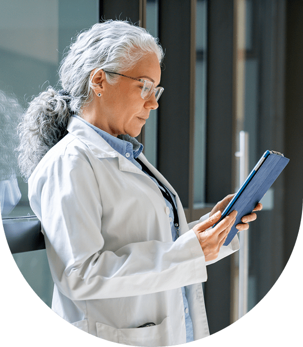 Senior scientist examining a book in a lab coat.