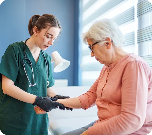 Nurse checking elderly woman's pulse in a bright room.
