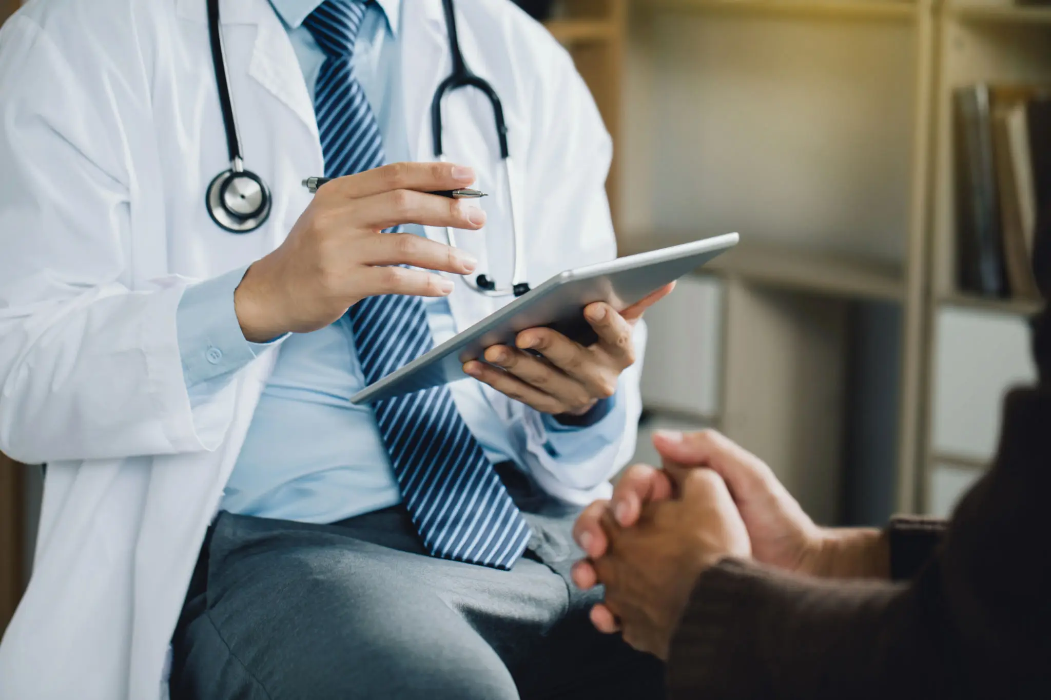 Doctor using a digital tablet during a patient consultation.